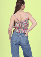 Back pose of woman wearing a strappy ruffle top with blue jeans