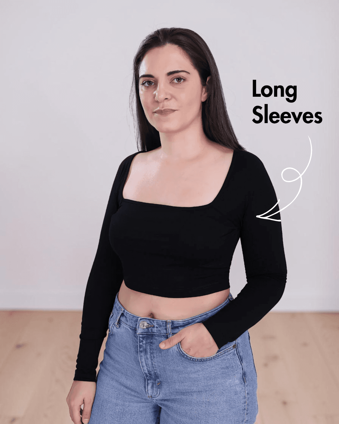 Side view of Woman wearing black square neck crop top with long sleeves and high-waisted jeans