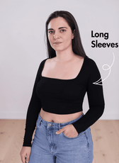 Side view of Woman wearing black square neck crop top with long sleeves and high-waisted jeans