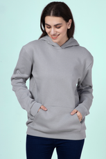 Woman wearing a gray hoodie with hands in the kangaroo pocket, showcasing the comfortable and casual design of the 'Rhea' sewing pattern.