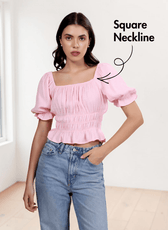 Model wearing pink puff sleeve top with square neckline and elastic shirring