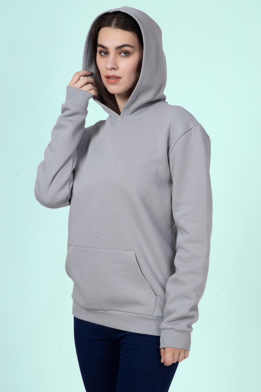 Model wearing a gray hoodie with the hood up, highlighting the spacious and cozy hood design of the 'Rhea' sewing pattern.