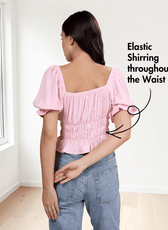 back view of pink cottagecore top with puff sleeves, ruched bodice, and flared hem