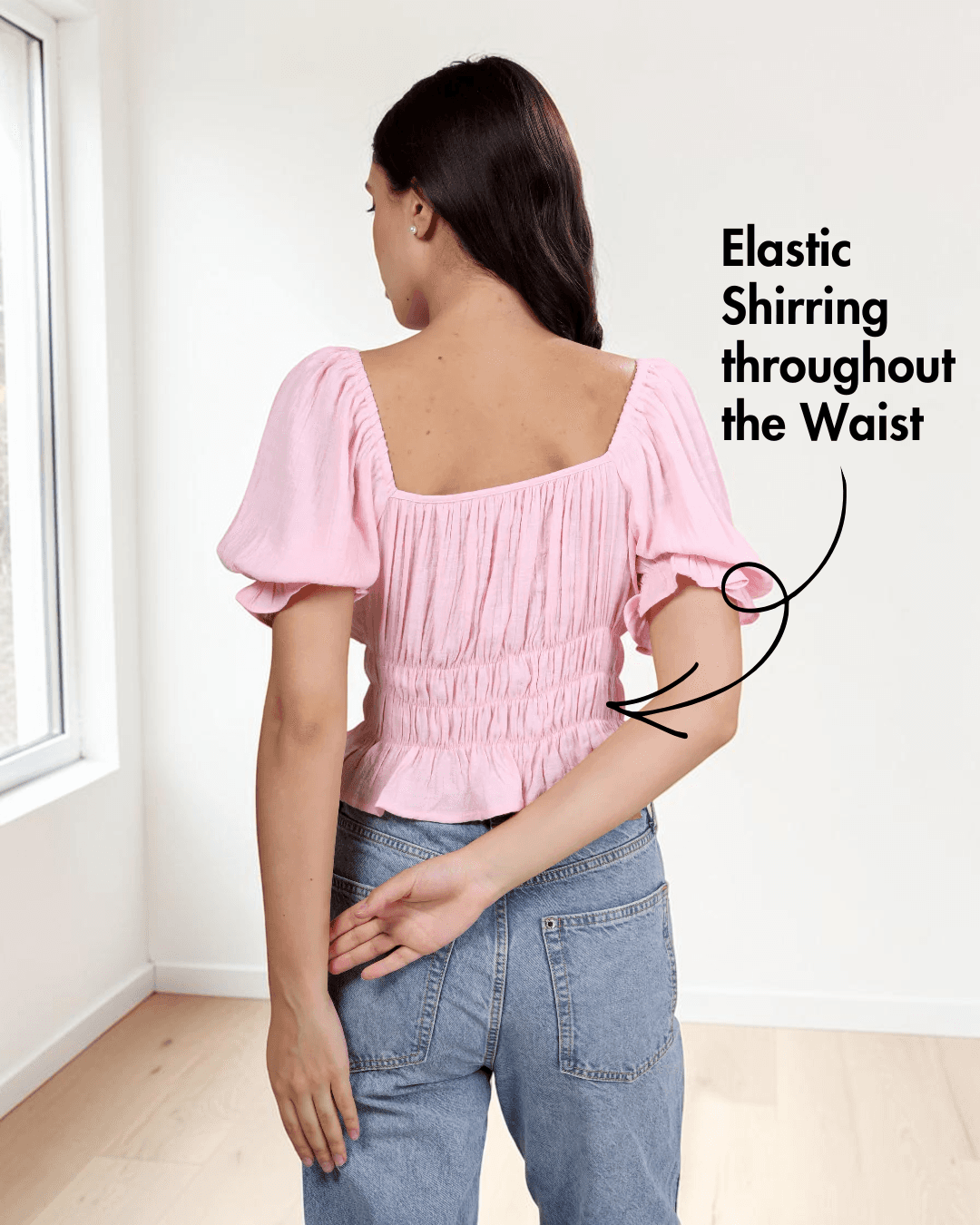 back view of pink cottagecore top with puff sleeves, ruched bodice, and flared hem