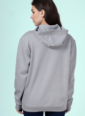 Back view of a woman wearing a gray hoodie, showcasing the hood and structured ribbed hem of the 'Rhea' sewing pattern.
