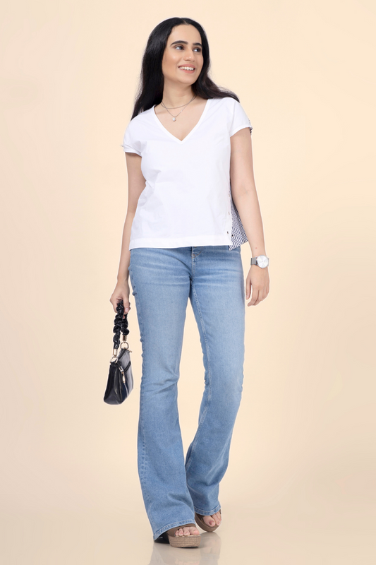 Woman styled in a V-neck relaxed top with side button details, created from Winslet's sewing pattern. A versatile and beginner-friendly sewing project.