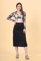 Model wearing a crop shirt with a pointed hem and long sleeves paired with a black midi skirt