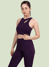 Model wearing Layla cutout sports bra in deep purple. Features a stylish cutout neckline and racerback design, perfect for activewear or casual outfits.