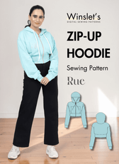 Women wearing light blue zip-up hoodie with drawstring hood, front zipper, and black pants, showcasing the sewing pattern for a cropped hoodie