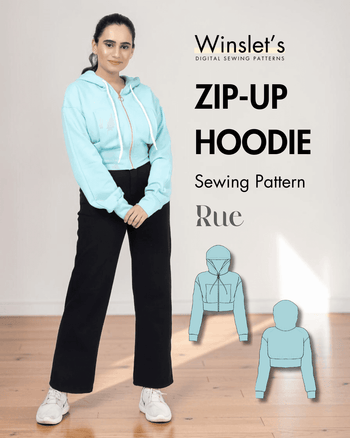 Women wearing light blue zip-up hoodie with drawstring hood, front zipper, and black pants, showcasing the sewing pattern for a cropped hoodie
