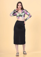 Full length shot of a Model wearing a crop shirt with a pointed hem and long sleeves paired with a black midi skirt