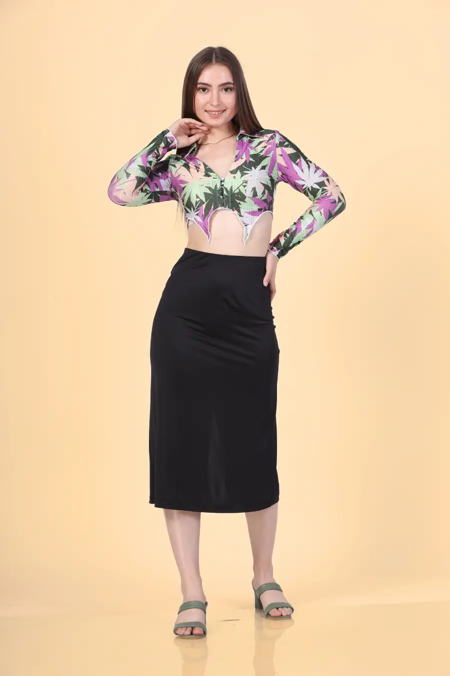 Full length shot of a Model wearing a crop shirt with a pointed hem and long sleeves paired with a black midi skirt