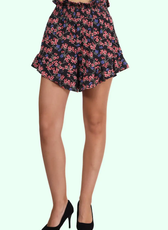 Close-up of high-waisted ruffle hem shorts with a smocked waistband and floral print. Features a relaxed fit and feminine ruffle details.