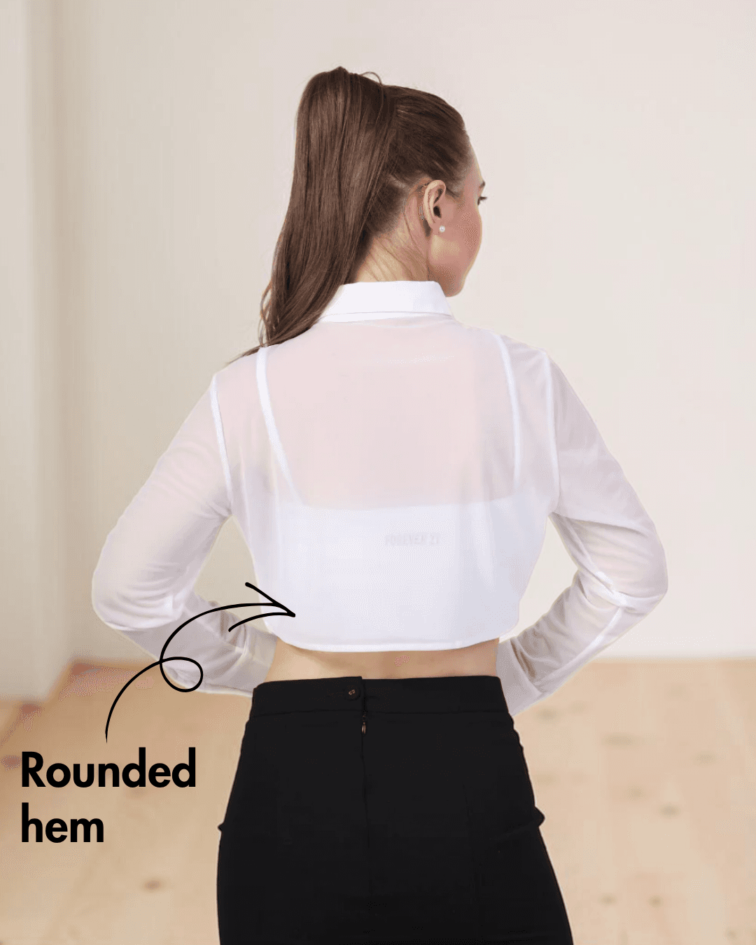 Back view of white cropped shirt with rounded hem and long sleeves