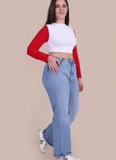 Model wearing Stella Long Sleeve Crop Top in white with red sleeves, paired with blue jeans. A trendy and easy-to-make sewing pattern.