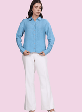 Model wearing a light blue oversized button-down shirt made using the 'Hayden' sewing pattern. Features a structured collar, long sleeves, and curved hem.