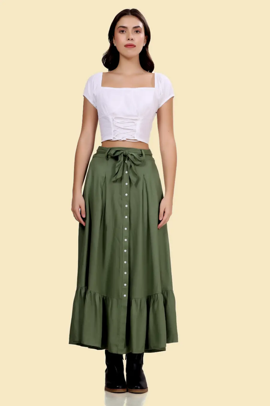 Green cottagecore maxi skirt with a high waist, buttoned front, and ruffled hem. Styled with a white crop top for a vintage-inspired look.