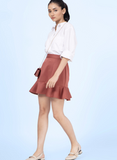 Model wearing a frill skirt made using the 'Buttercup' sewing pattern. Features a fitted waist, flared hem, and back zipper for a structured yet playful look.