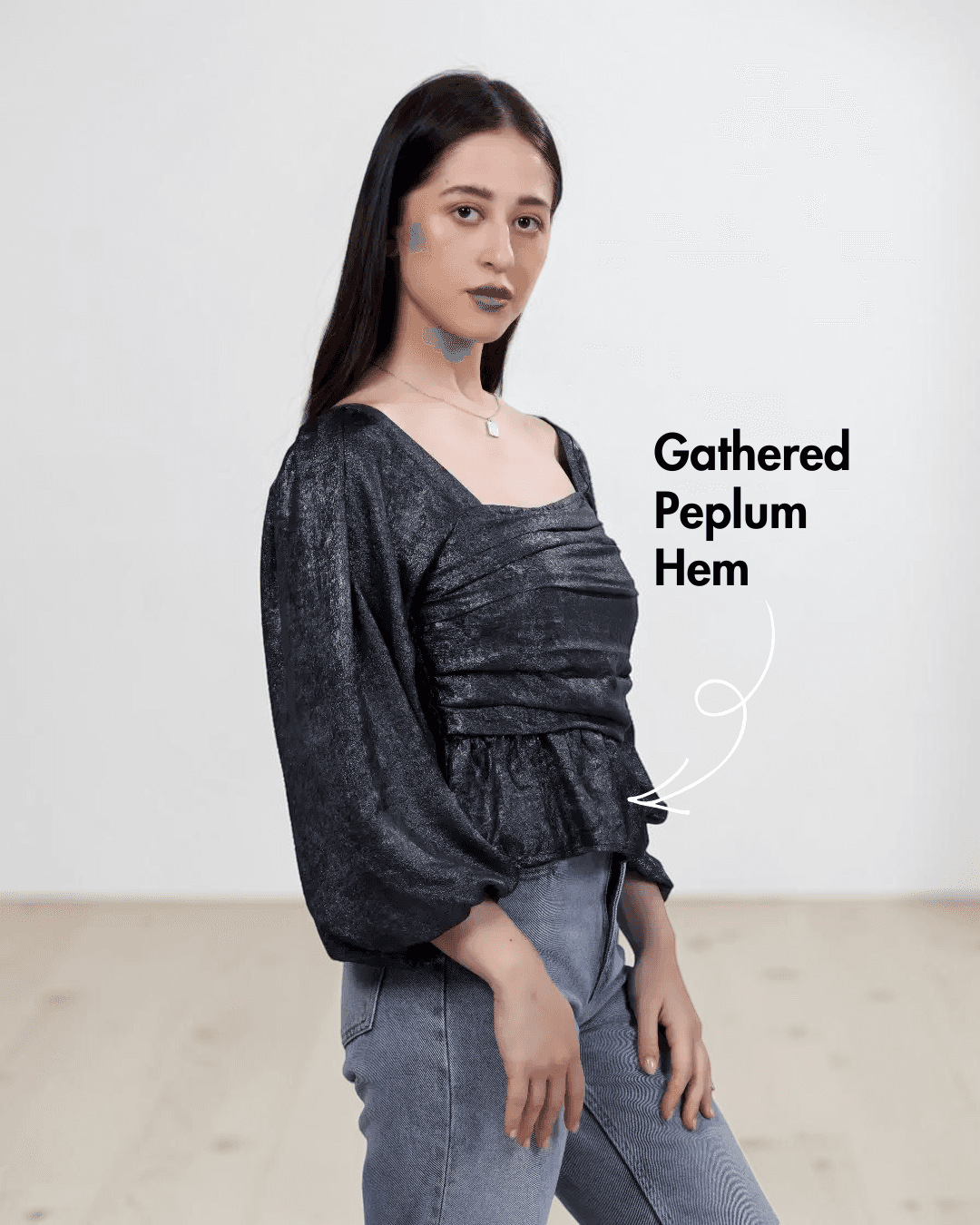 Women's black gathered peplum hem sewing pattern with smocked back and puff long sleeves, side view