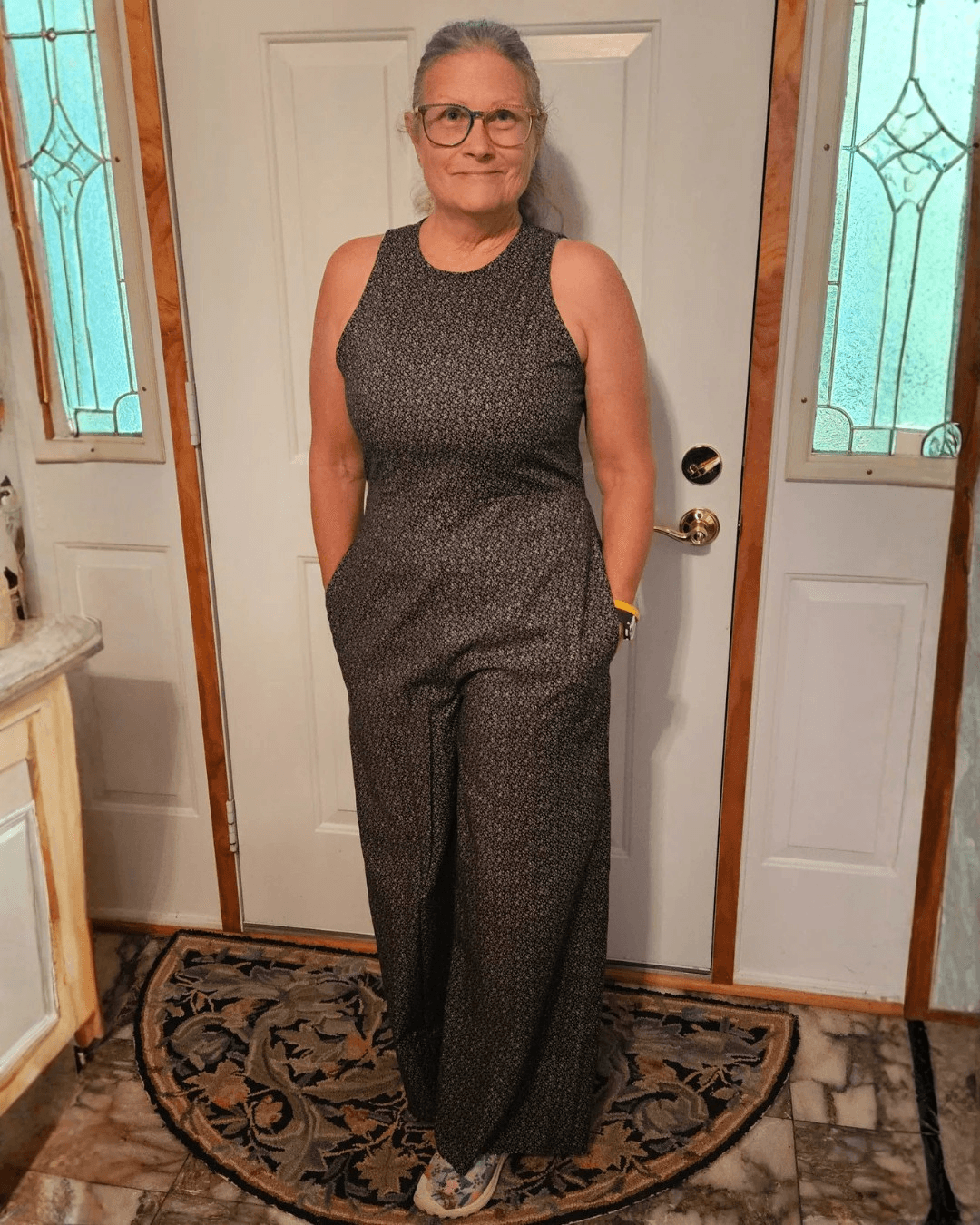 Customer wearing a fitted jumpsuit with back zipper and wide-leg pants for formal wear