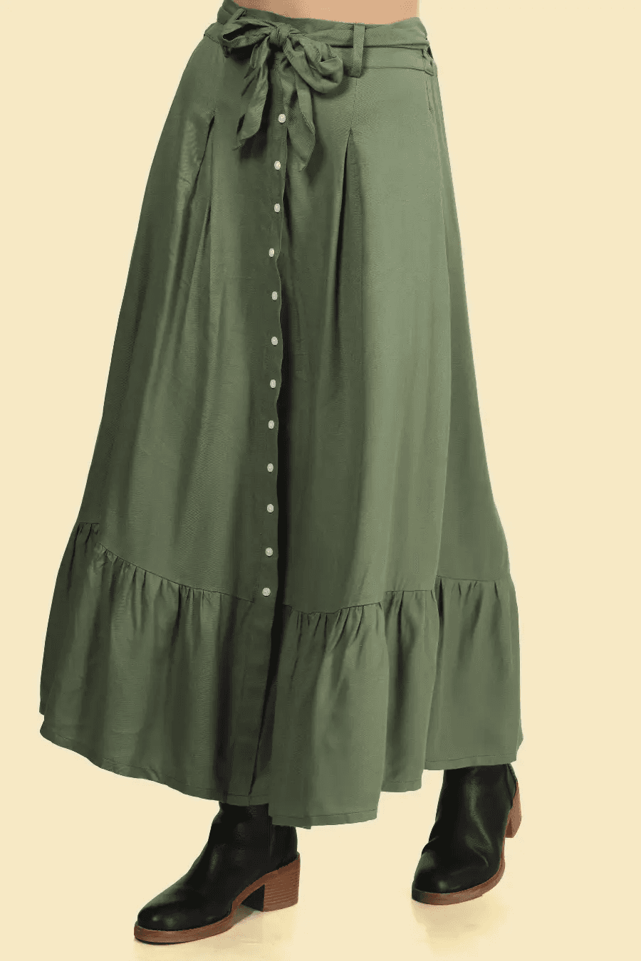 Close-up of a green maxi skirt with a bow-tied belt, buttoned front, and ruffled hem. A stylish and practical addition to any wardrobe.