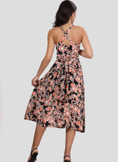 Back view of the 'Camellia' wrap dress highlighting the cross-back straps and waist tie. The flared skirt provides a feminine silhouette.