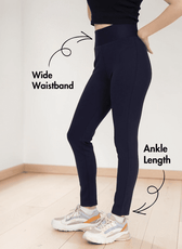 Close-up of woman in navy leggings sewing pattern showing wide waistband and ankle length