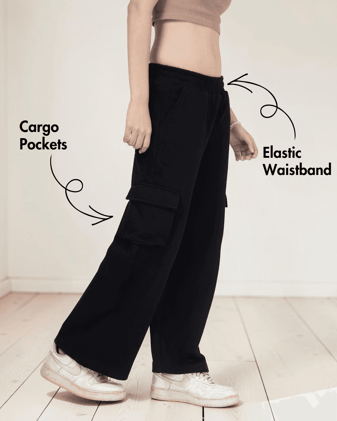 Close-up of black cargo sweatpants with cargo pockets and elastic waistband