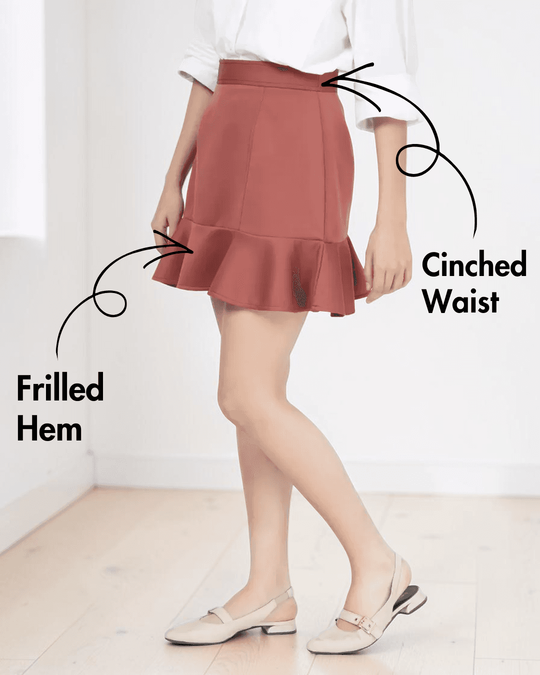 Model wearing rust-colored flounced hem mini skirt with cinched waist and back zipper