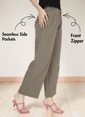 Close-up of beige wide-leg trousers with front zipper and side pockets, styled with pink heels