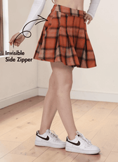 Close-up of a pleated mini skirt with side zipper, worn by a model with hand on hip