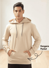 Model wearing beige hoodie sewing pattern with kangaroo pocket and ribbed cuffs
