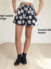 Model wearing navy floral high-waisted shorts with side pockets and black ankle boots
