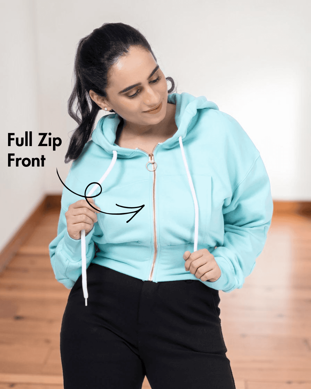 Close-up of woman in light blue zip-up hoodie with full front zipper, highlighting the sewing pattern details for a women's crop jacket