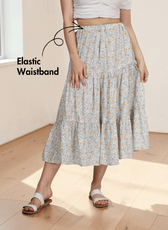 Woman wearing floral tiered midi skirt with elastic waistband and flowy silhouette