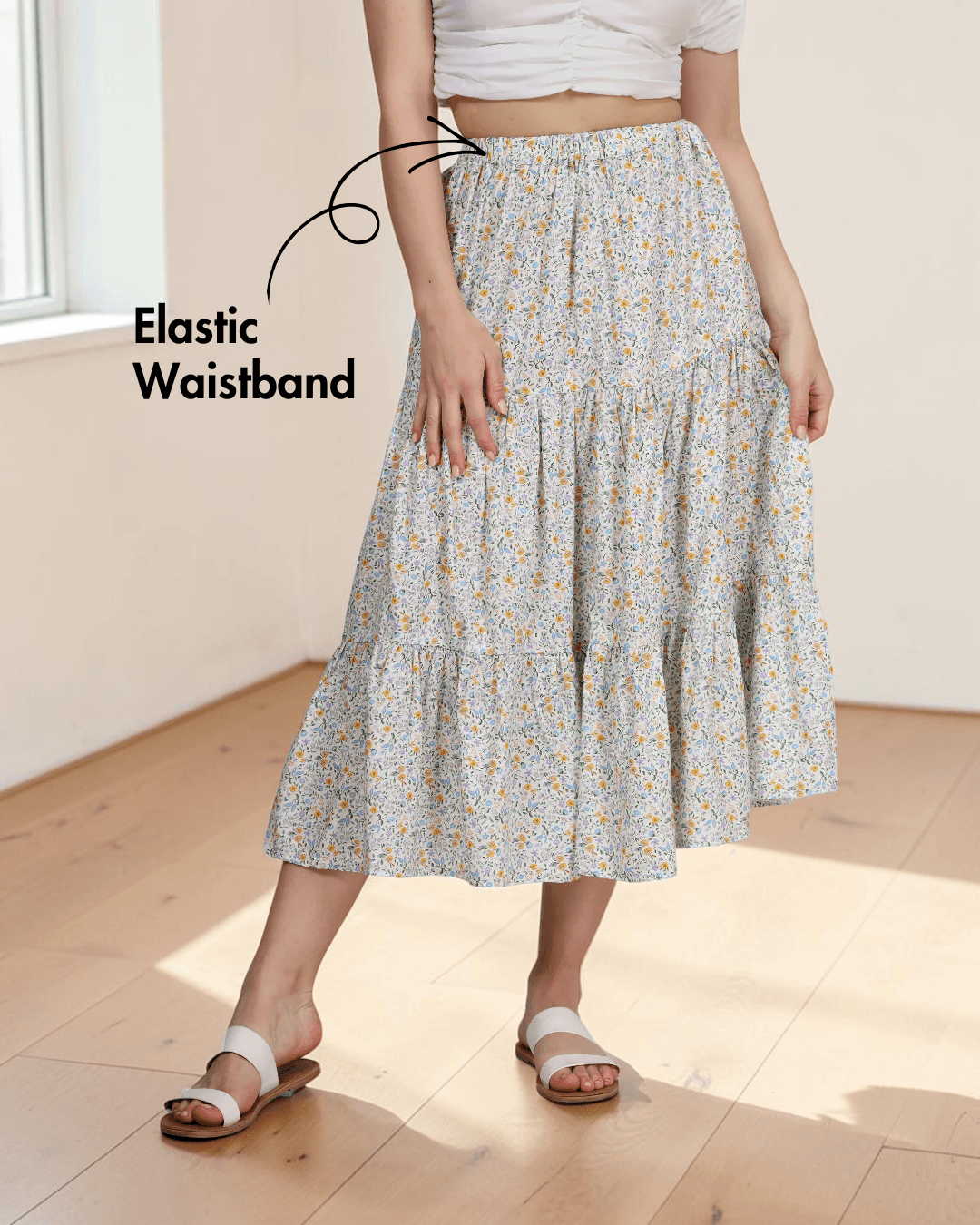 Woman wearing floral tiered midi skirt with elastic waistband and flowy silhouette