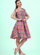 Side angle view of a Model wearing a sleeveless midi dress with adjustable tie-shoulder straps