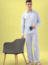 Model holding a coffee mug while wearing the 'Arbor' men's pajama set. A relaxed loungewear sewing pattern with a long-sleeve shirt and matching pants.