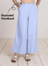 Close-up of light blue wide leg pants with elastic waistband, showing functional side pockets