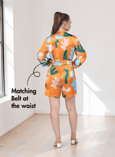 Model wearing floral playsuit with matching belt and long sleeves, back view