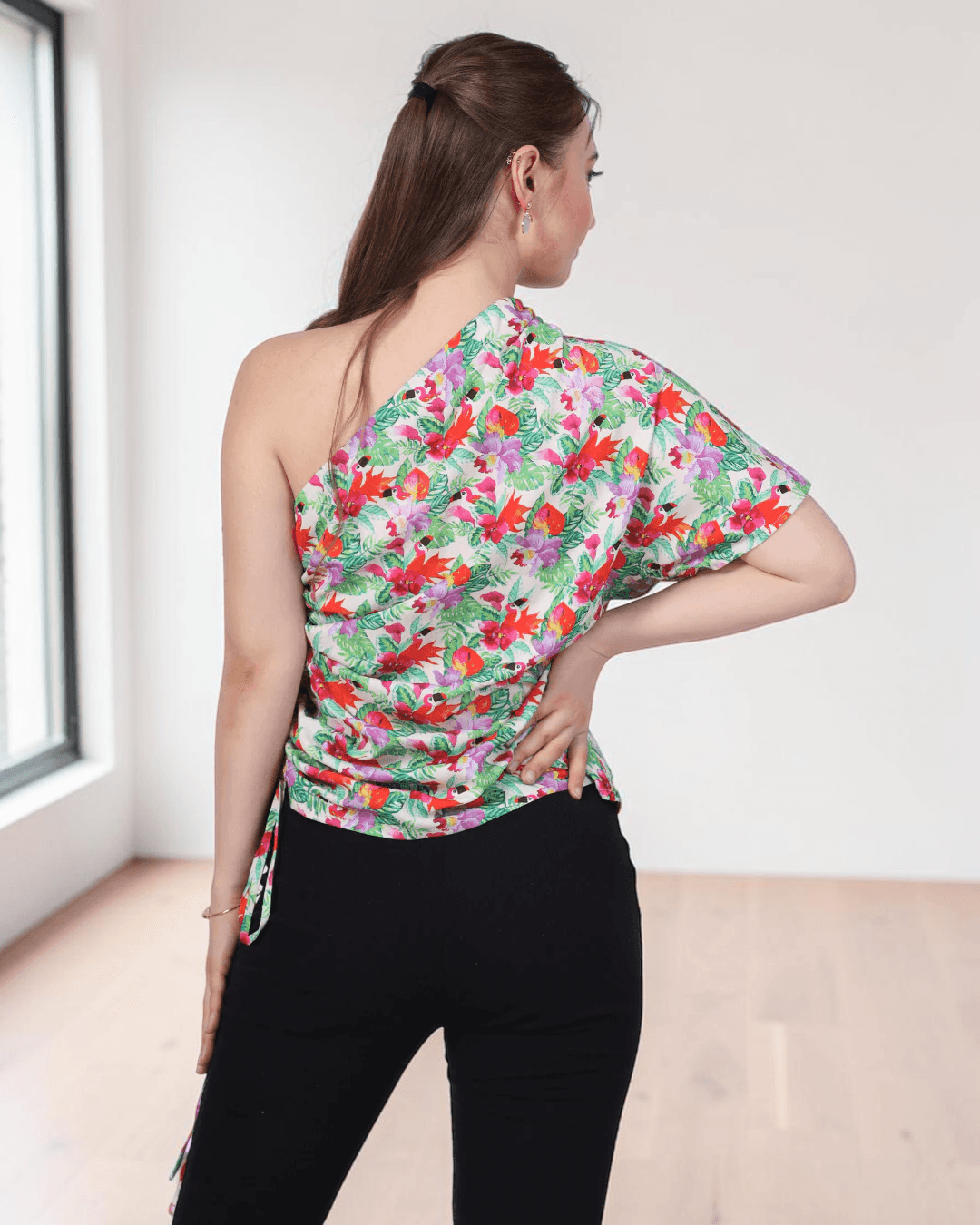 Back view of floral one shoulder kimono top with asymmetric neckline, side tie detail, and pattern design