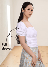 Side view of white puff sleeve top with smocked back panel and floral skirt