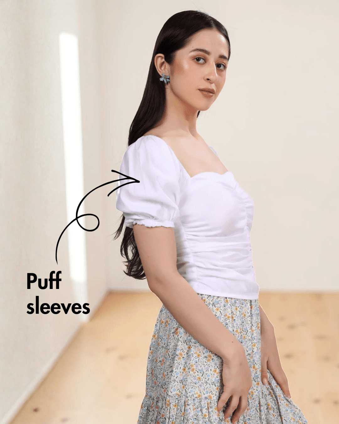 Side view of white puff sleeve top with smocked back panel and floral skirt