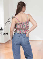 Back view of woman in pink ruffle top with slim straps and elastic waist