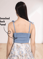 Back view of blue smocked back panel crop top with tie straps