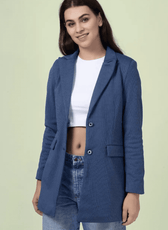 Model wearing a blue straight-cut coat made using the 'Camille' sewing pattern. The design includes a notched lapel, single-breasted closure, and flap pockets.