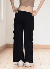 Close-up of black cargo sweatpants with cargo pockets and elastic waistband, back view