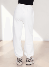Model wearing white joggers sewing pattern with elastic waistband and cuffed ankles, demonstrating pattern fit and style, back view