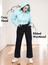 Woman in gray hoodie with ribbed waistband and drawstrings, showing the sewing pattern for a stylish hooded sweatshirt