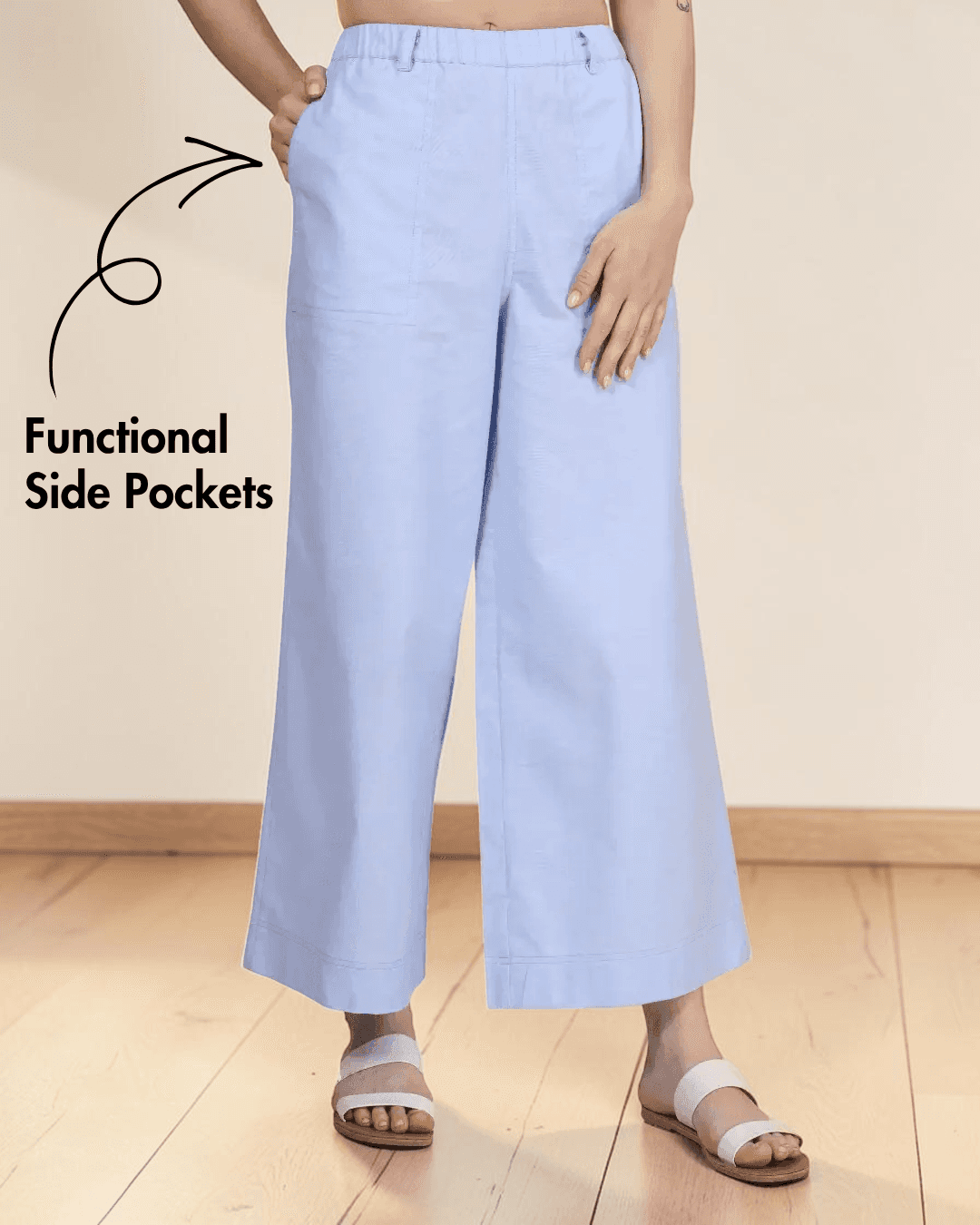 Close-up of light blue wide leg pants with elastic waistband, showing functional side pockets, side view